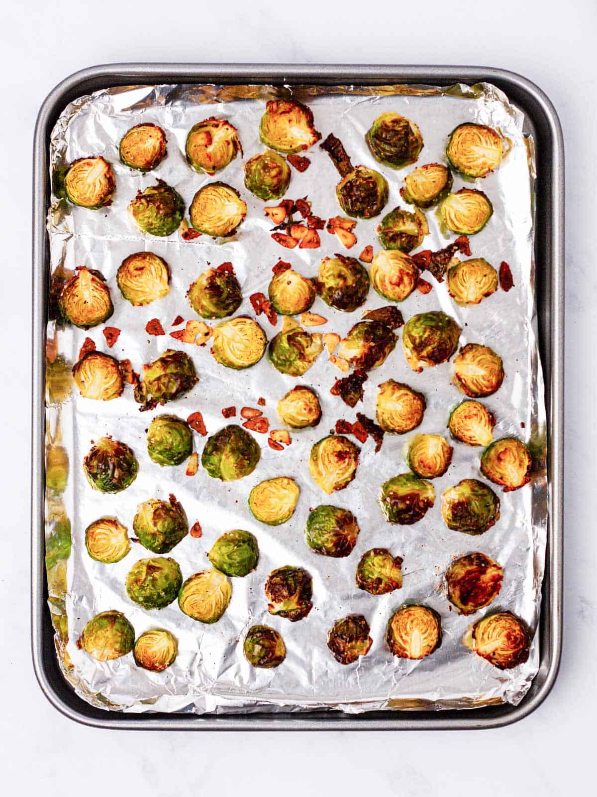 overhead view of roasted Brussels sprouts on foil lined sheet pan