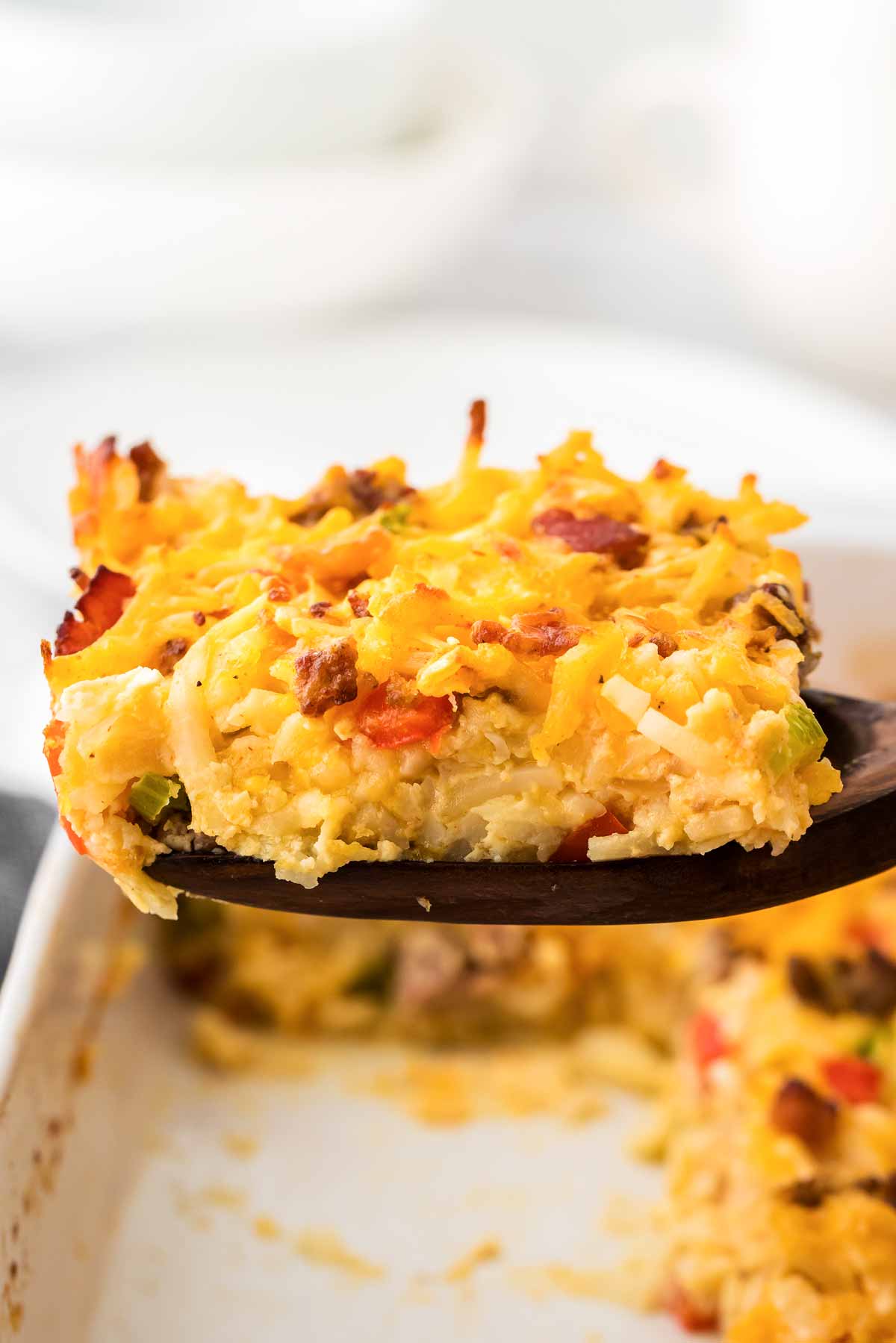 frontal view of hashbrown casserole on wooden spatula