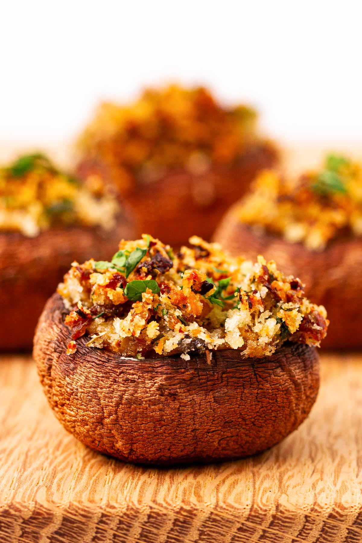 frontal view of stuffed mushroom on wooden chopping board