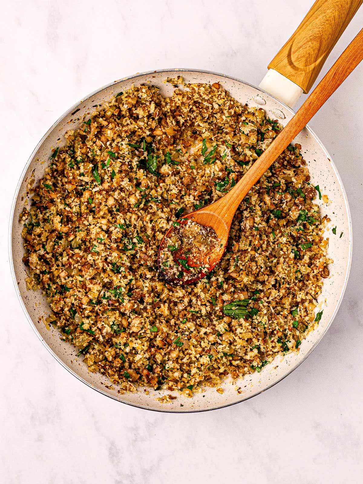 overhead view of stuffed mushroom filling in skillet with chopped parsley