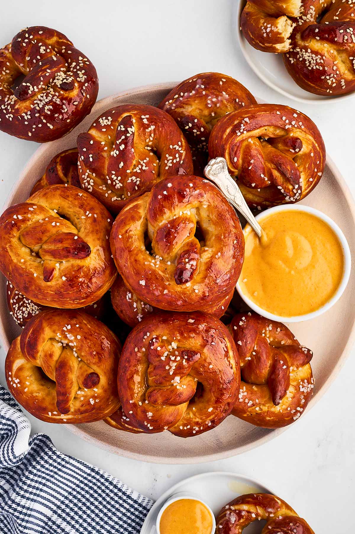 overhead view of soft pretzels on plate with bowl of cheese dip