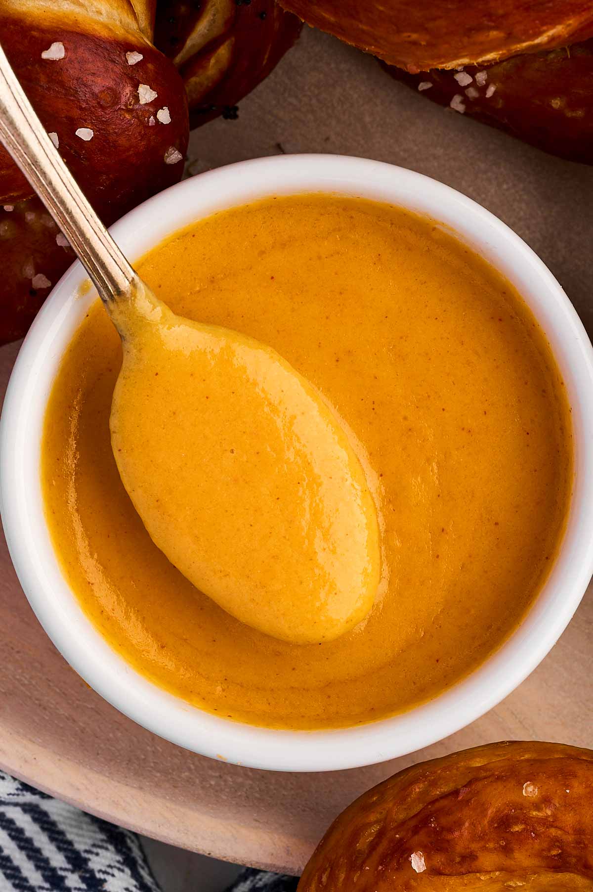 overhead view of spoon dipped in bowl with beer cheese dip