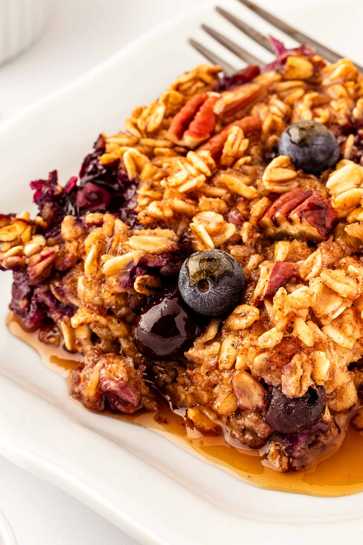 close up view of blueberry baked oatmeal on white plate