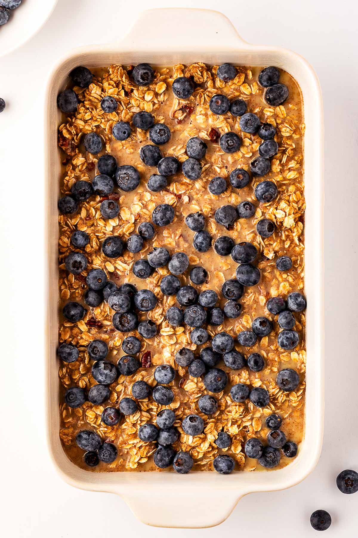 overhead view of oatmeal topped with blueberries in baking dish