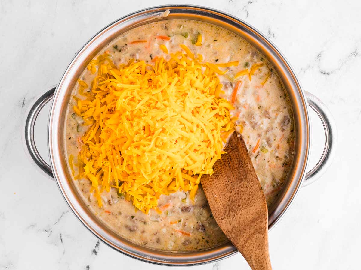 overhead view of cheddar on top of soup in pot