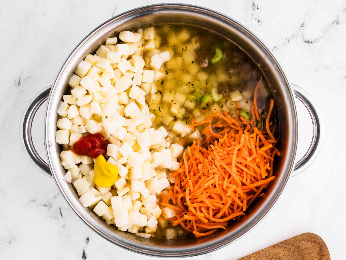 overhead view of diced hash browns and carrot in pot