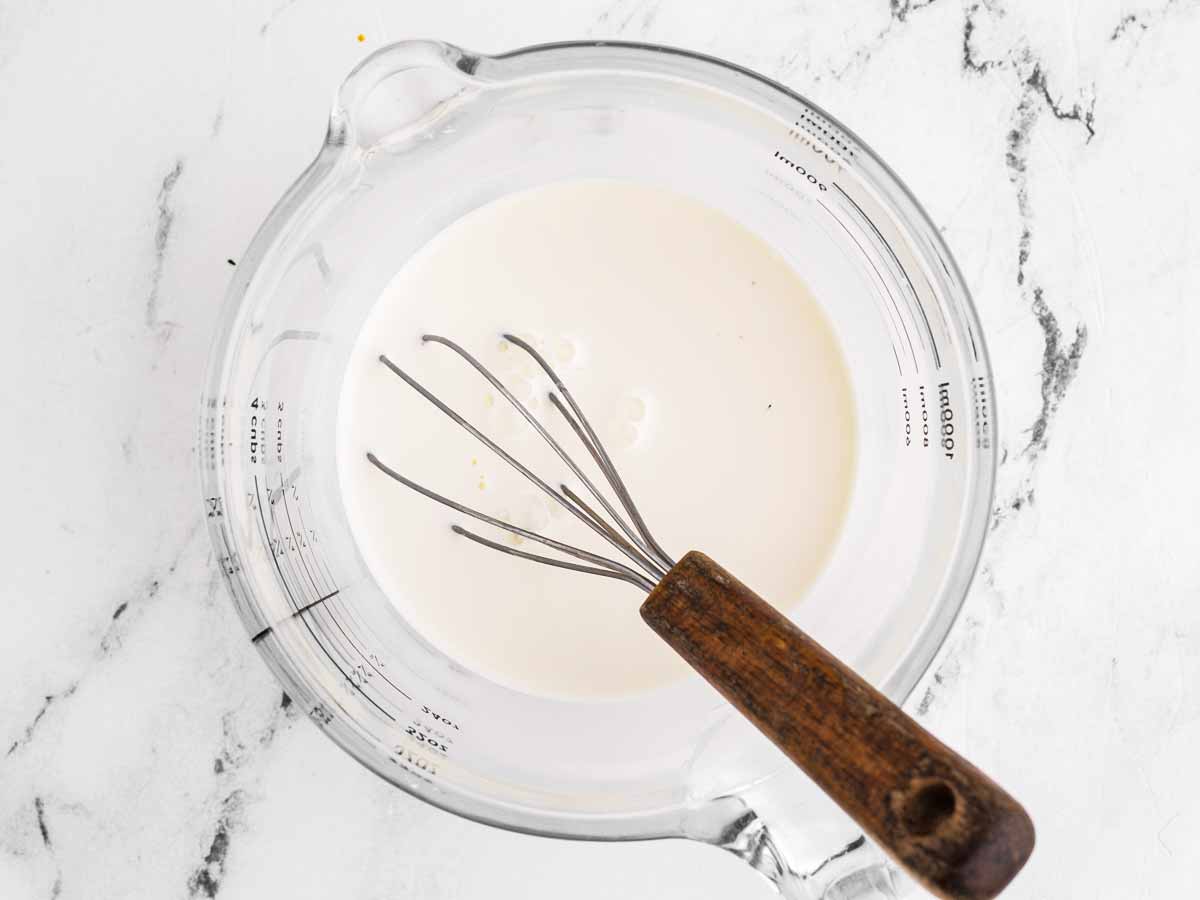 overhead view of cornstarch slurry in glass measuring cup