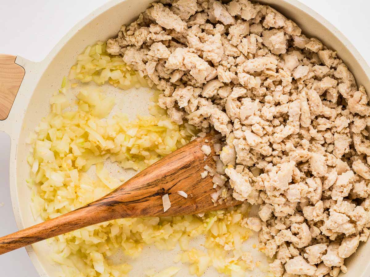 overhead view of ground chicken and garlic/ginger mixture in skillet