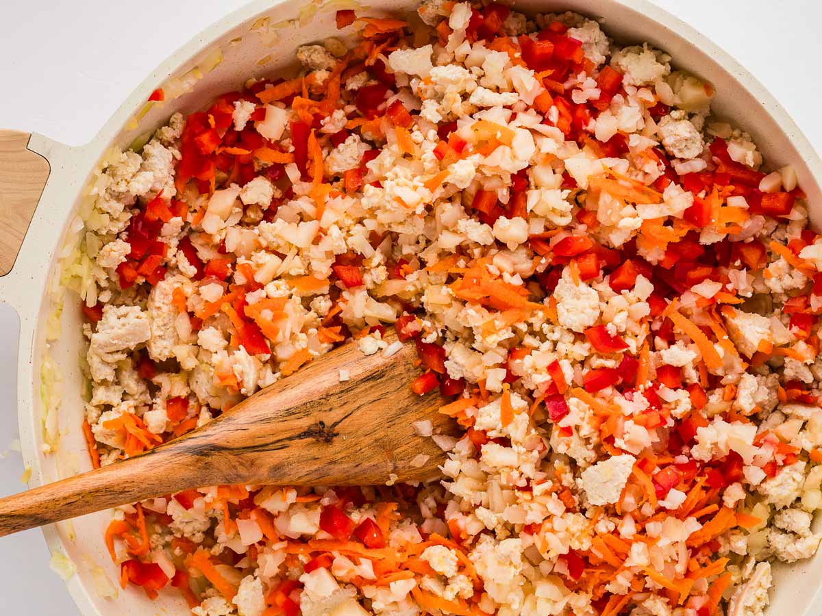 overhead view of vegetables and ground chicken browned in skillet