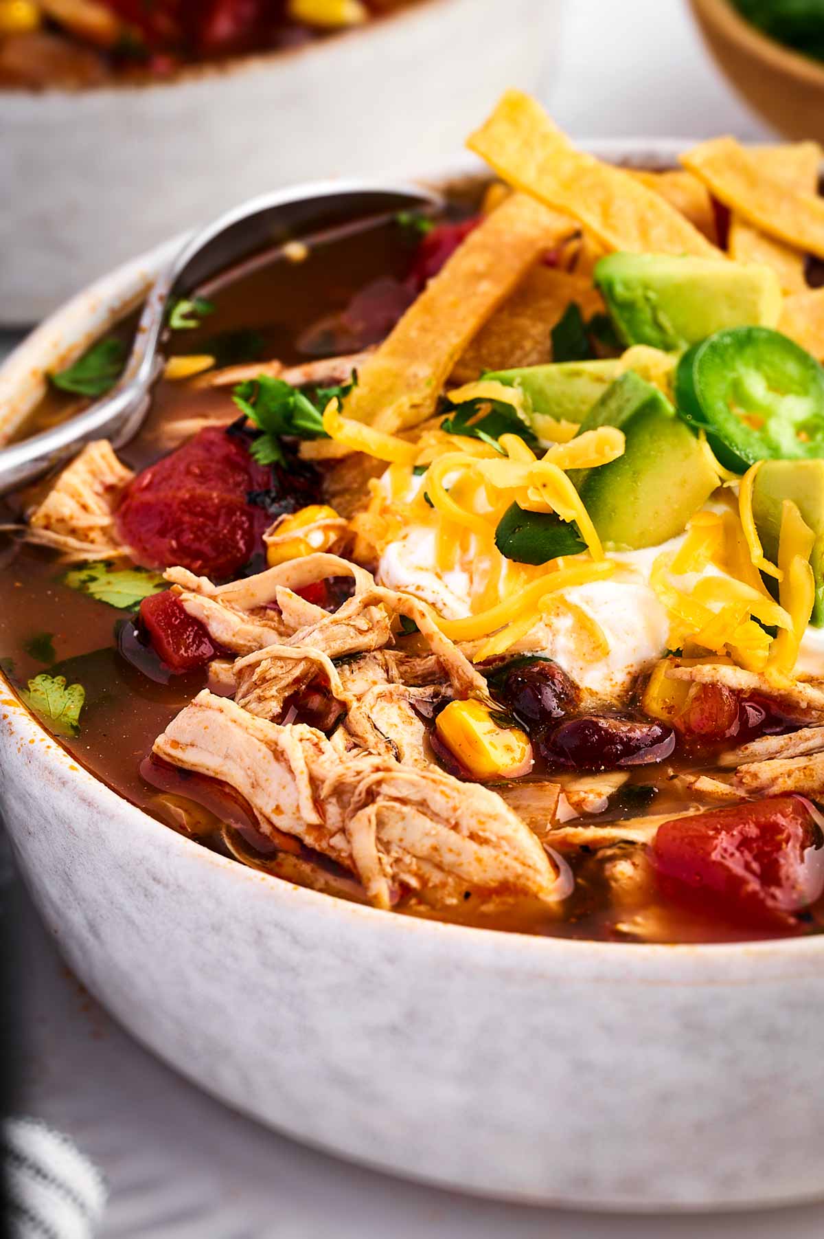 front view of chicken tortilla soup with toppings in bowl