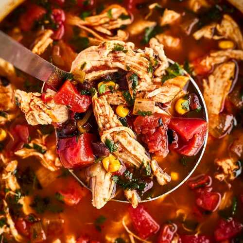 overhead view of ladle over chicken tortilla soup in pot