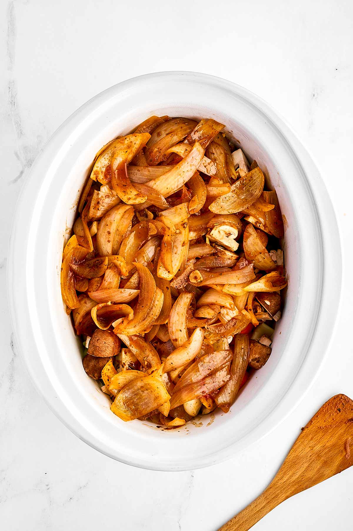 overhead view of uncooked beef stew in slow cooker