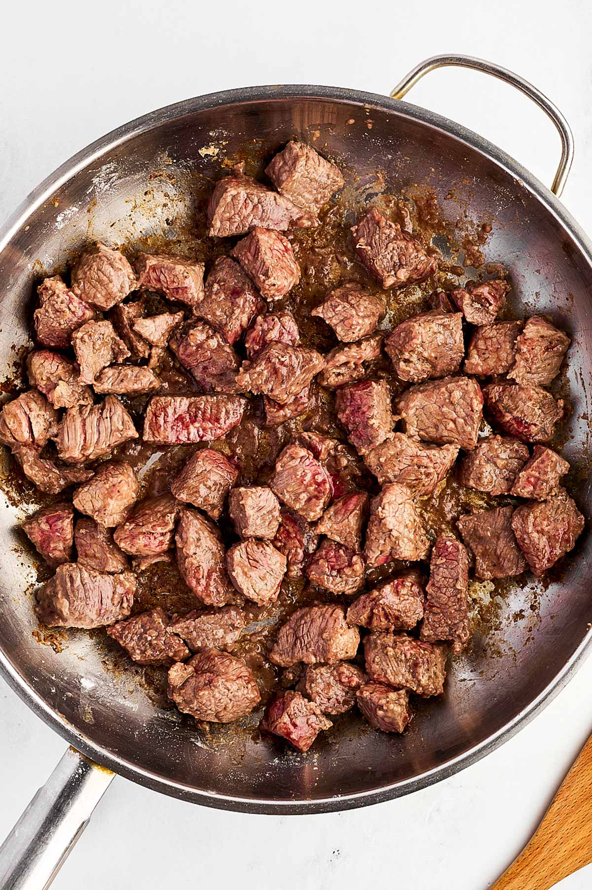 overhead view of browned beef cubes in skillet