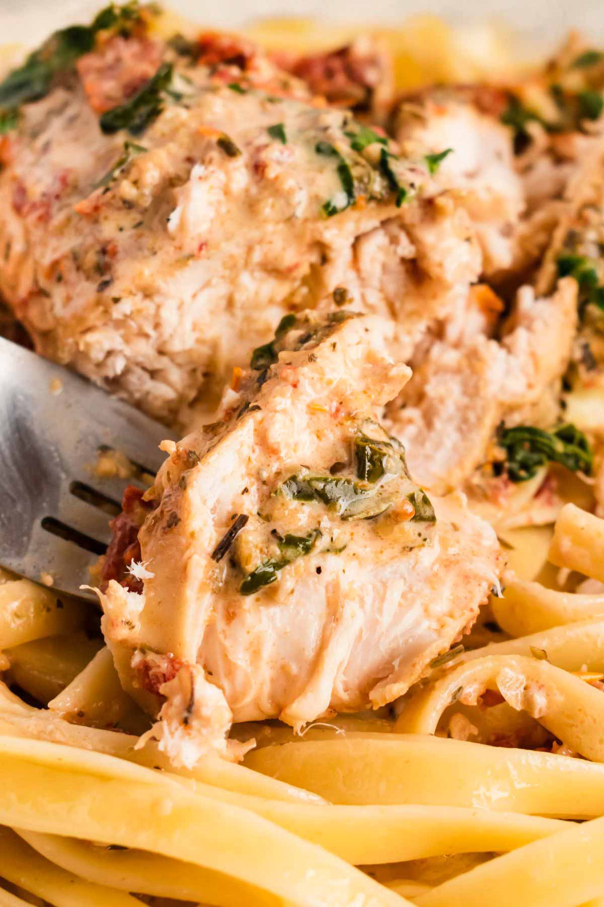 frontal close up of sliced tuscan chicken breast on fork