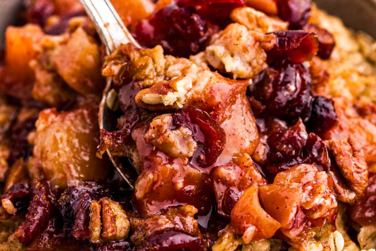 frontal close up view of crockpot apple cinnamon oatmeal with spoon in middle