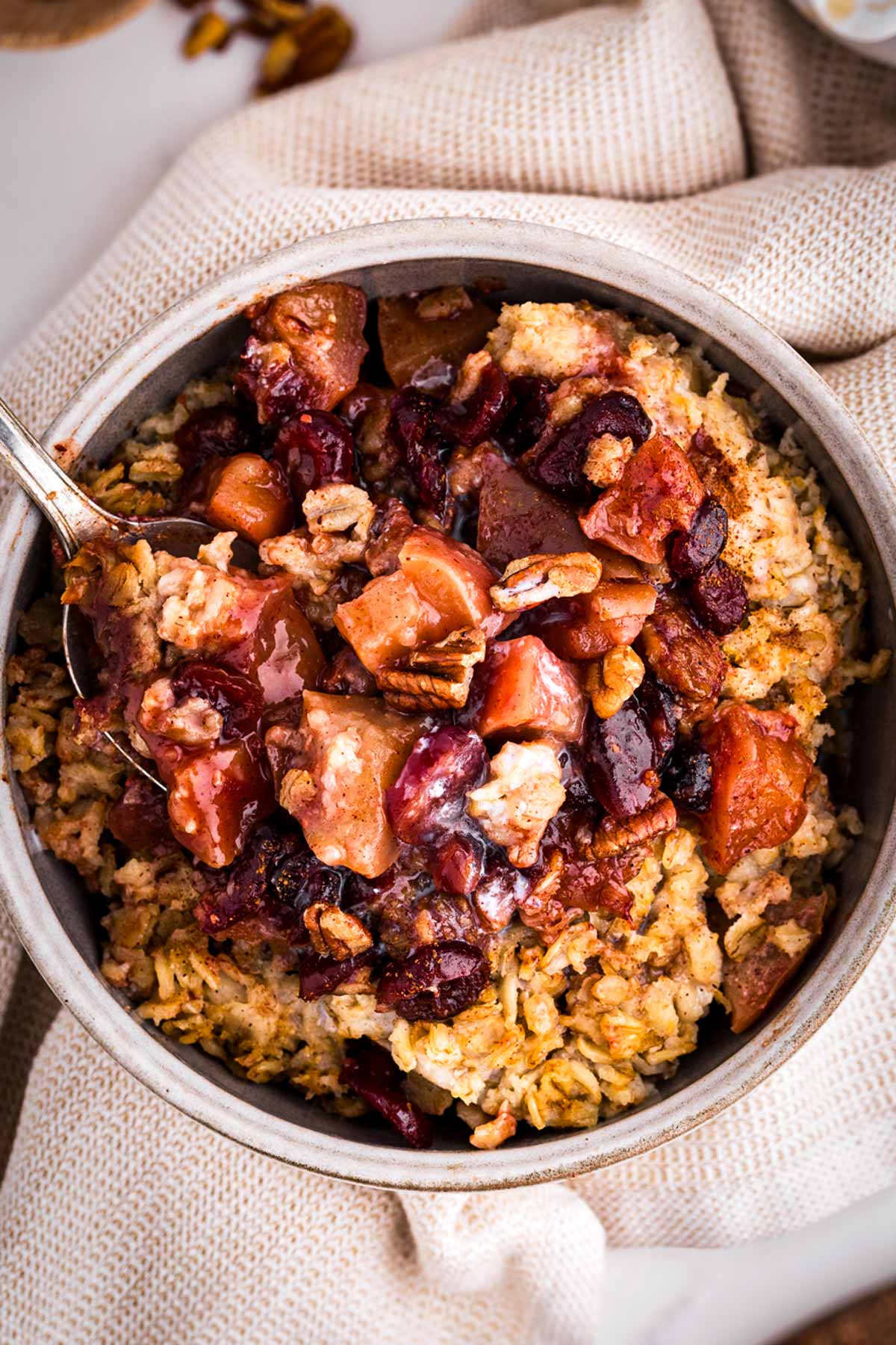 overhead view of bowl filled with oatmeal and apples