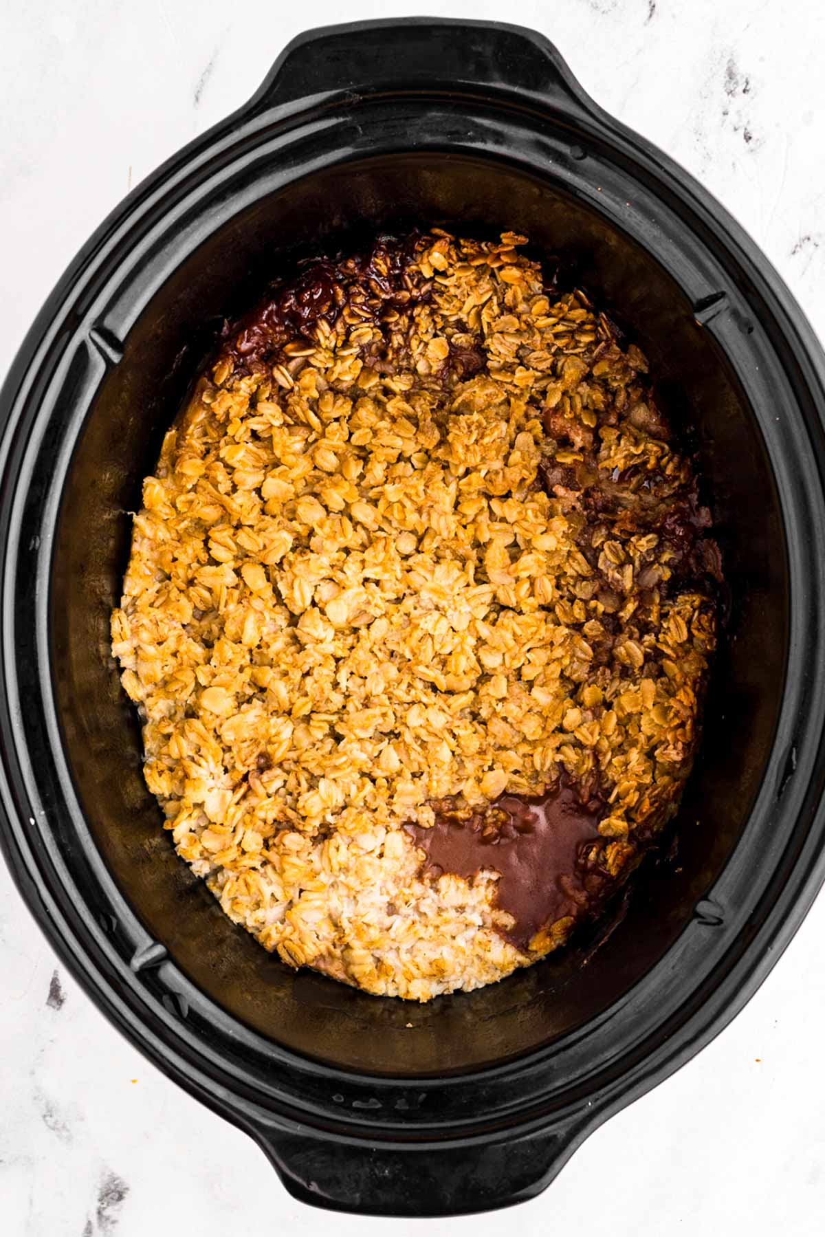 overhead view of baked oatmeal in black crockery slow cooker insert