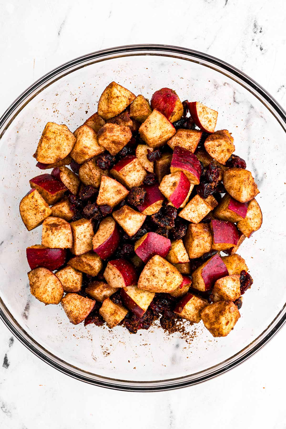 overhead view of apples in bowl with cranberries coated in cinnamon