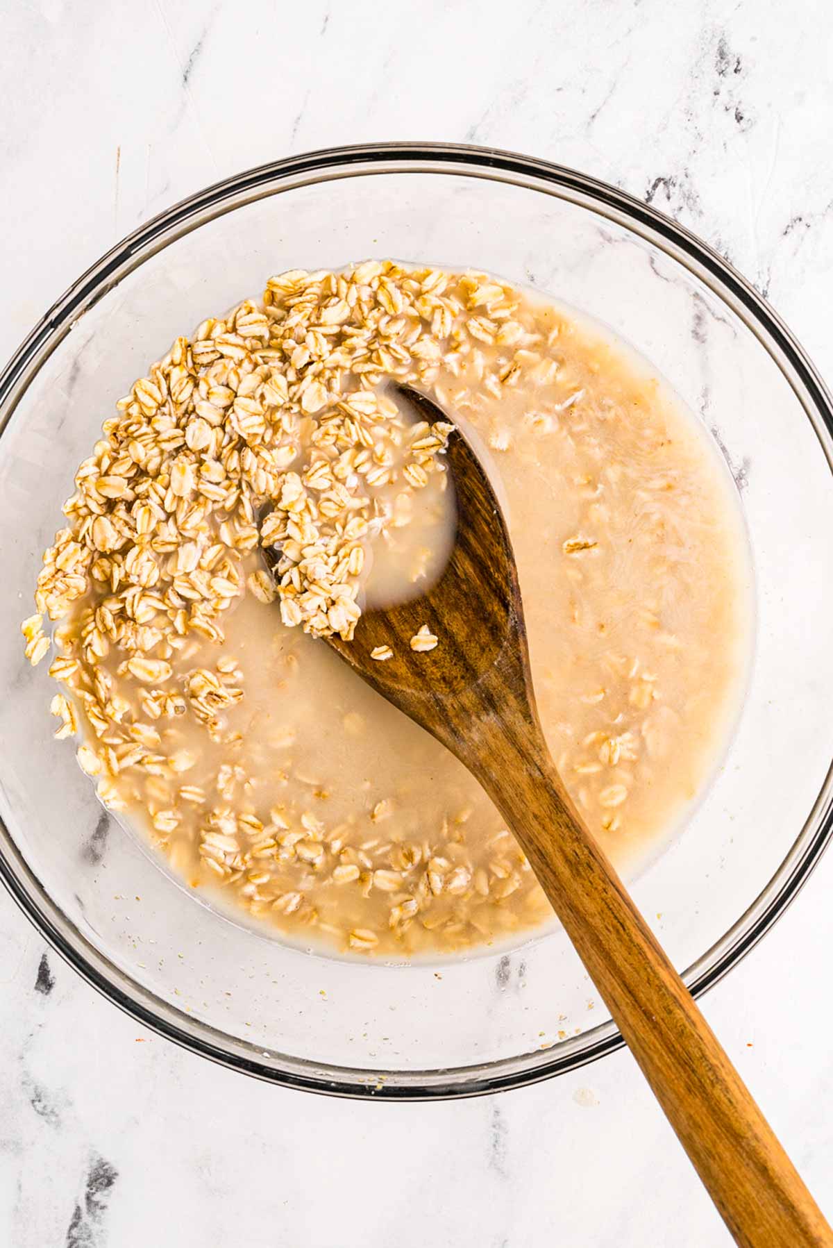 overhead view of oats with liquid in glass bowl