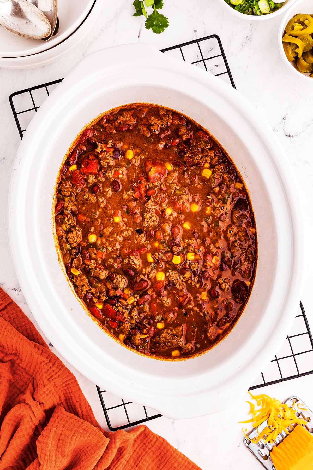 overhead view of crock filled with chili on top of black wire rack