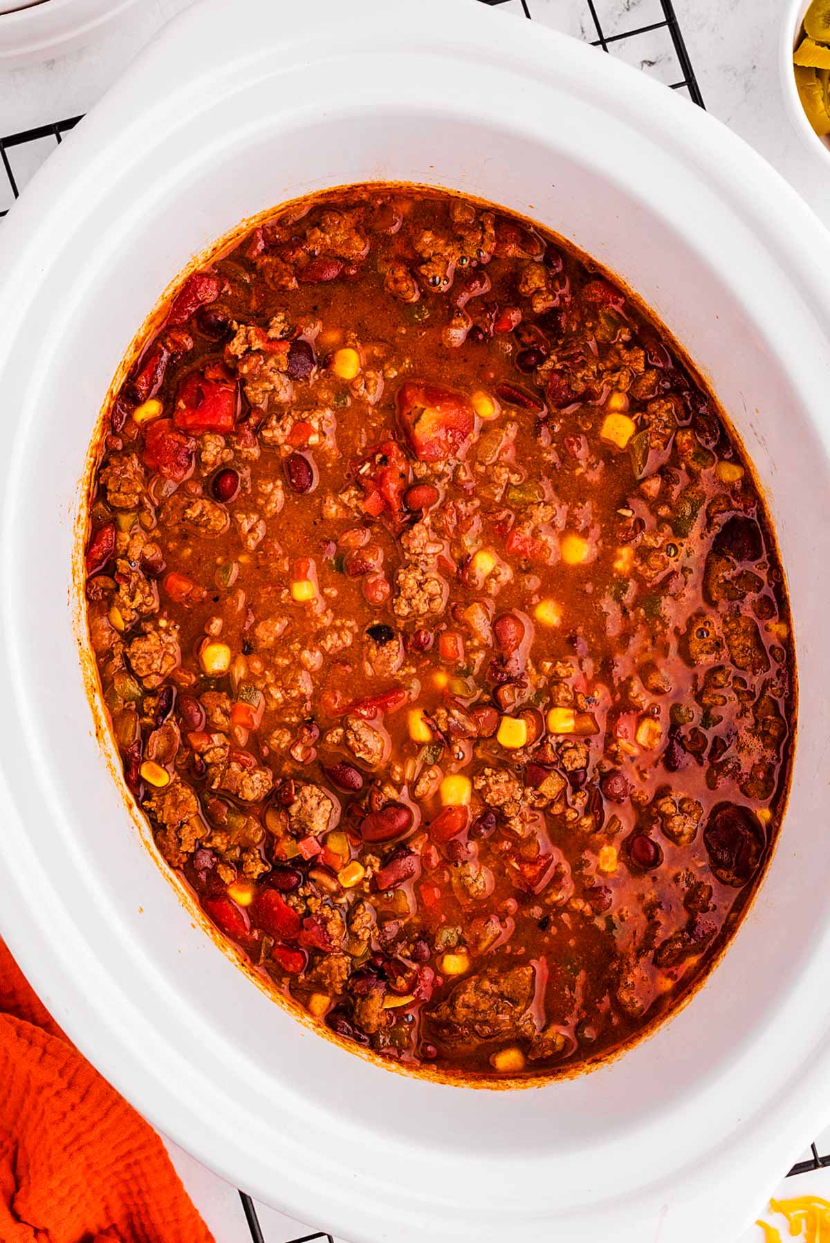 overhead view of ground beef chili in white slow cooker crock