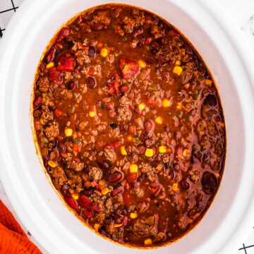 overhead view of ground beef chili in white slow cooker crock