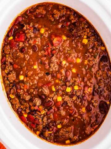 overhead view of ground beef chili in white slow cooker crock