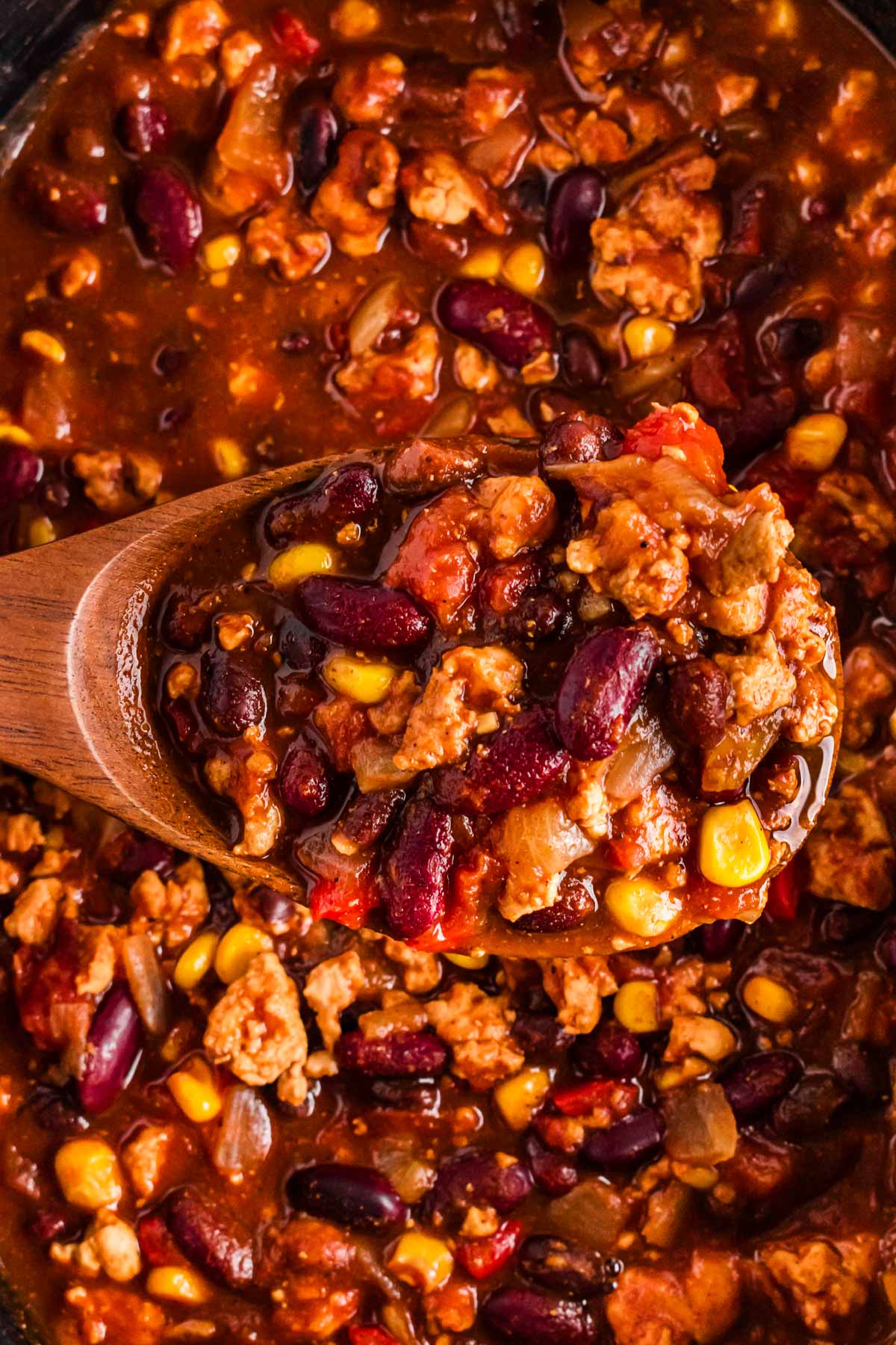 overhead view of spoon with turkey chili over crockpot