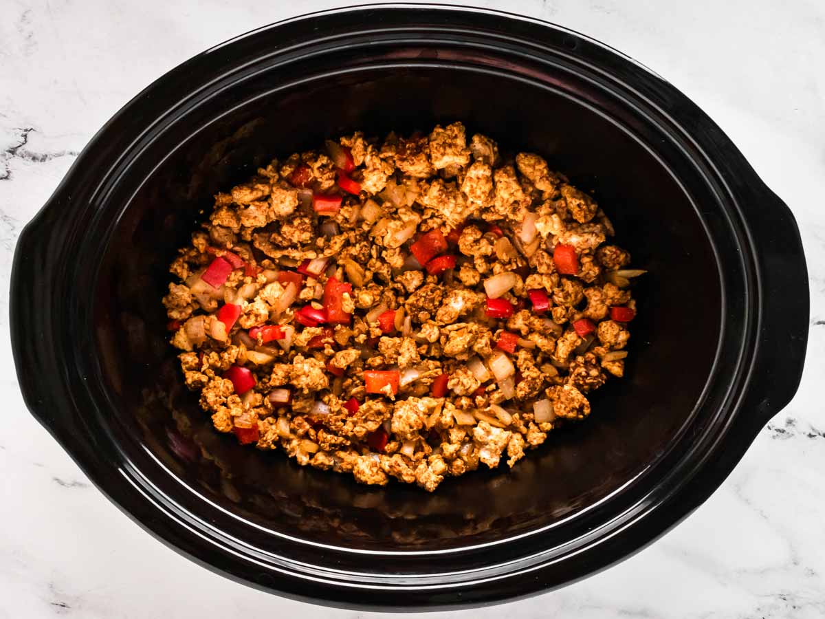 overhead view of turkey chili base in black slow cooker crock