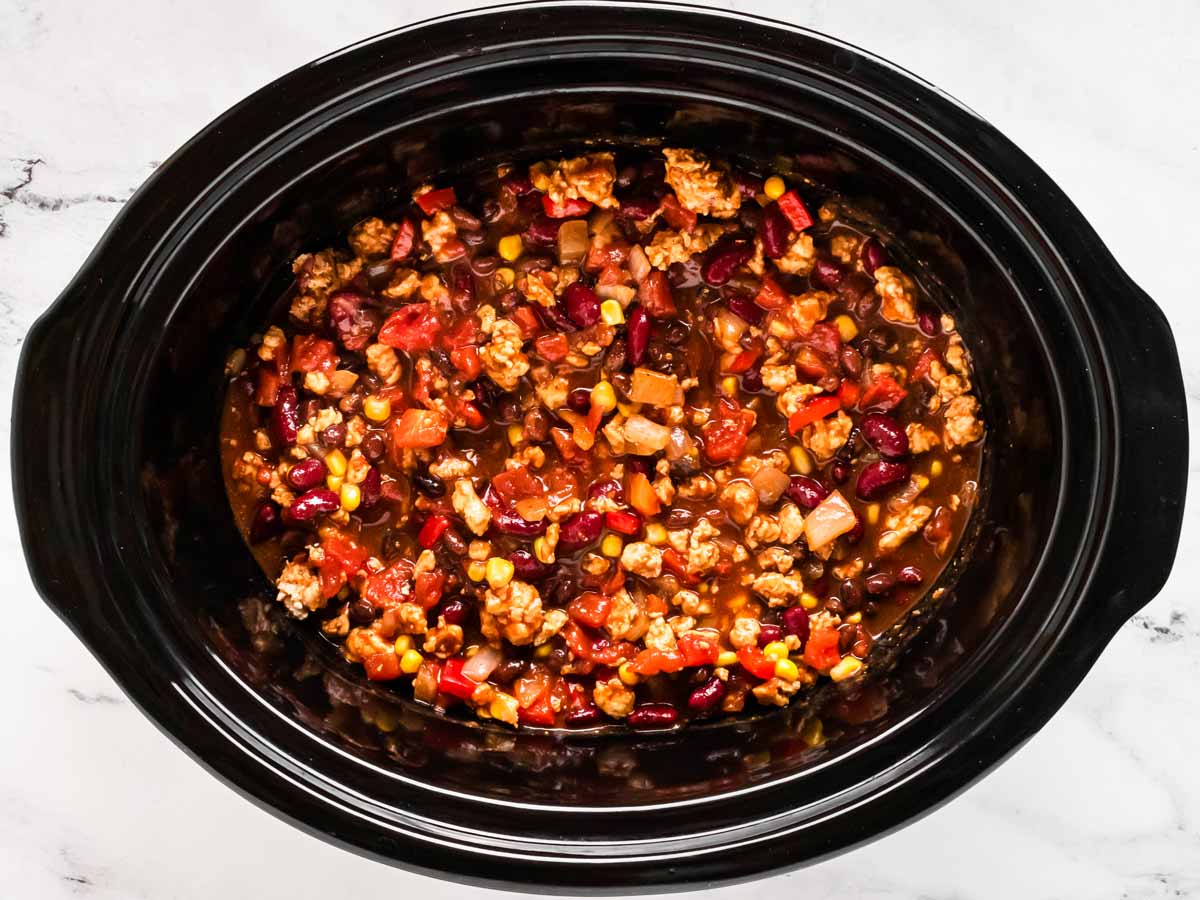 overhead view of uncooked turkey chili in slow cooker