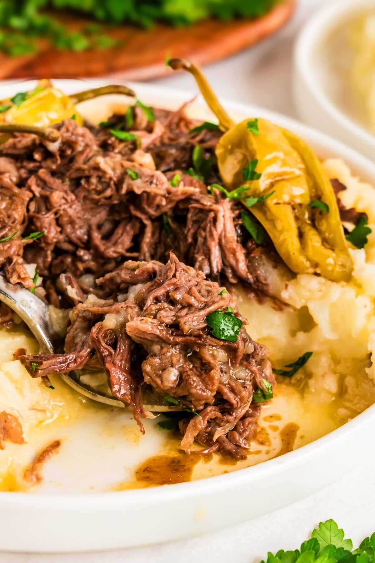 frontal close up of Mississippi pot roast on plate with mashed potatoes