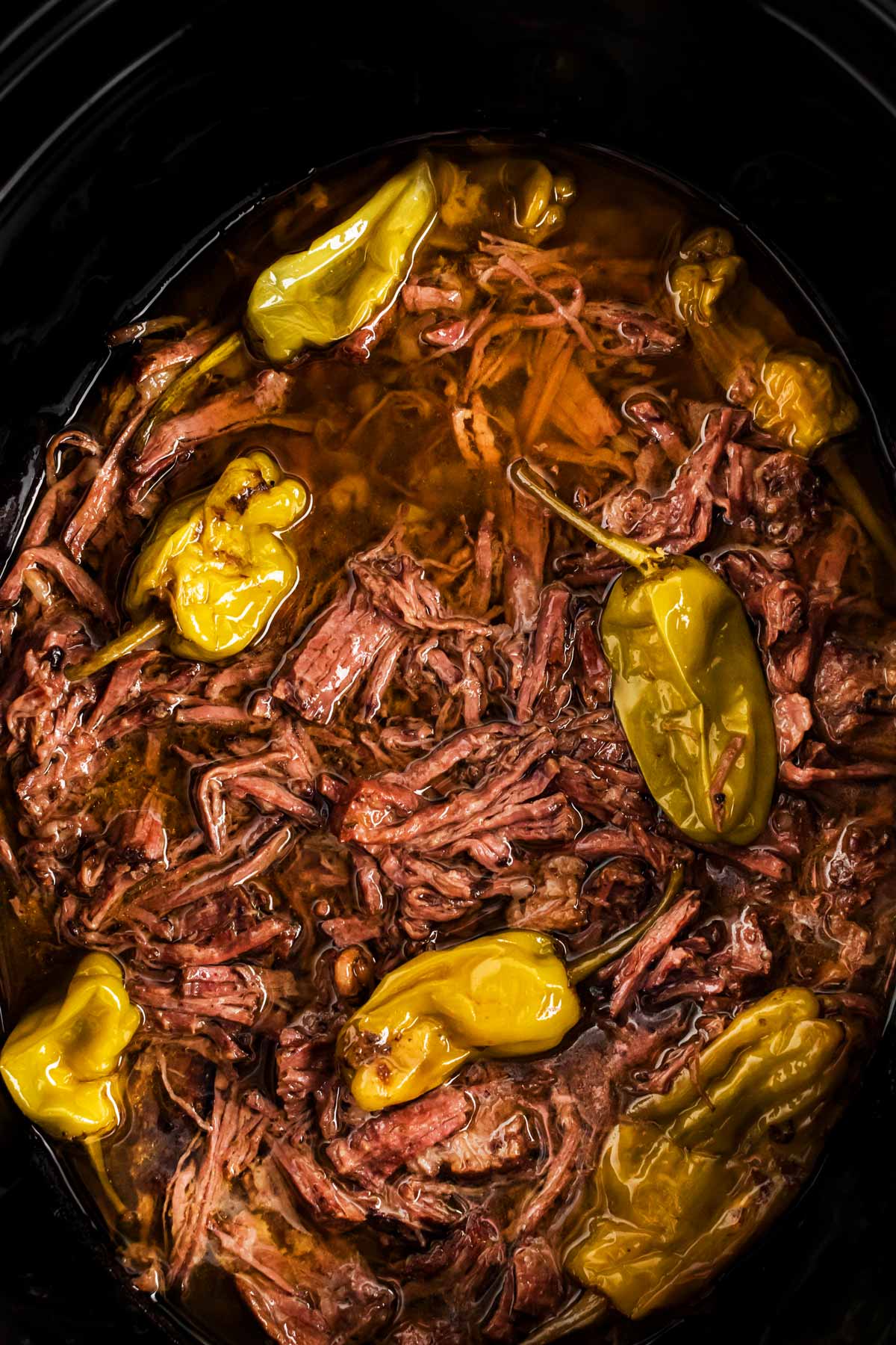 overhead close up view of Mississippi pot roast in black slow cooker crock