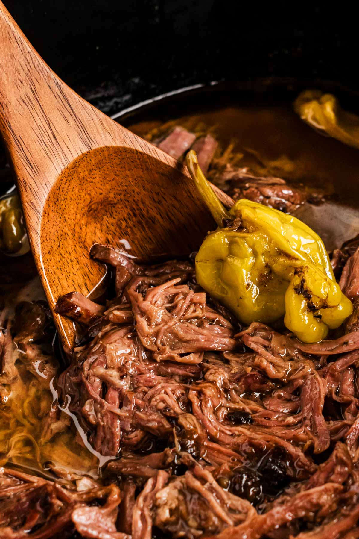 frontal close up of mississippi pot roast scooped on wooden spoon