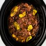 overhead close up view of Mississippi pot roast in black slow cooker crock