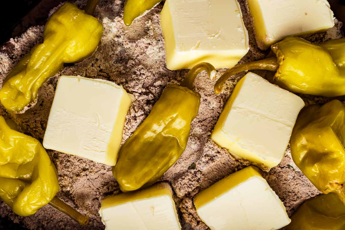 overhead close up of butter and pepperoncini on seasoning mix