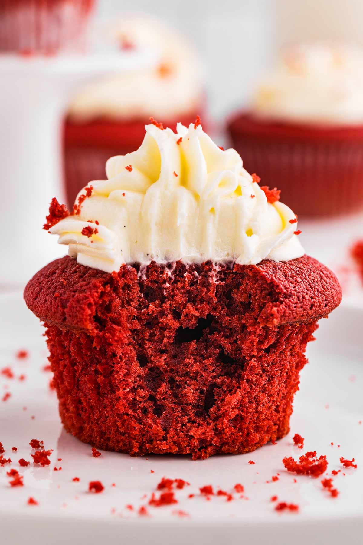 frontal view of red velvet cupcake with a bite taken out