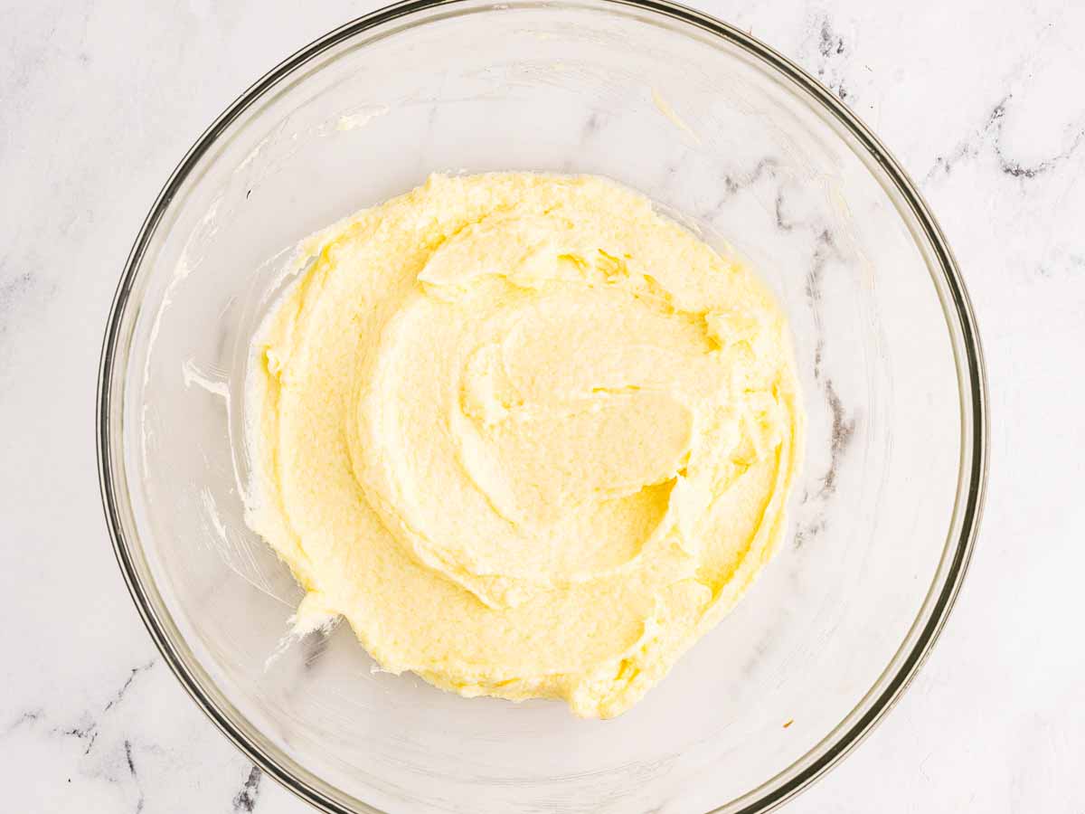 overhead view of creamed butter and eggs in glass bowl