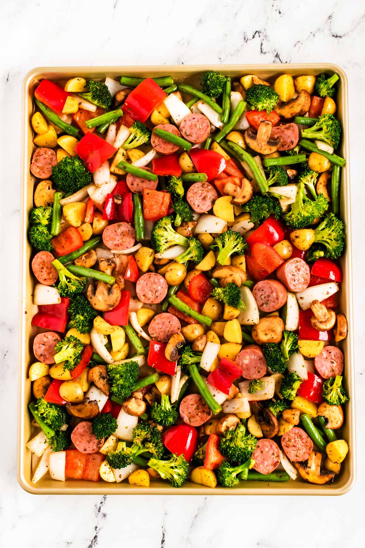 overhead view of vegetables and sausage on sheet pan