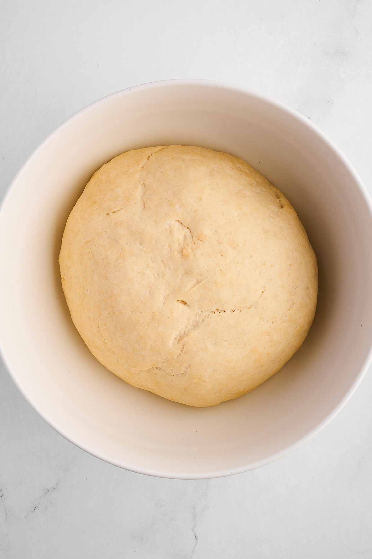 overhead view of risen dough in bowl