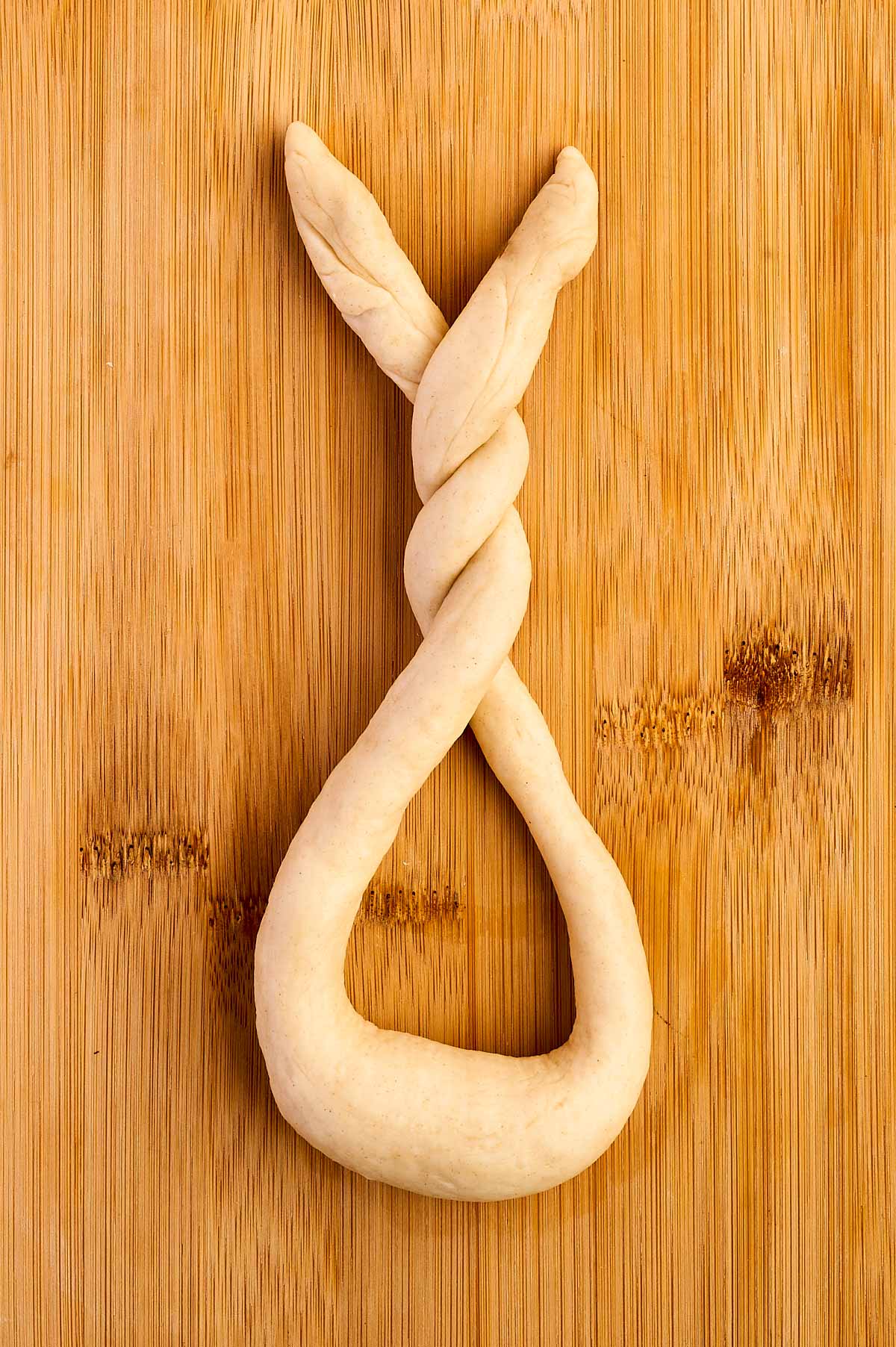 overhead view of dough strand in u shape with twisted ends