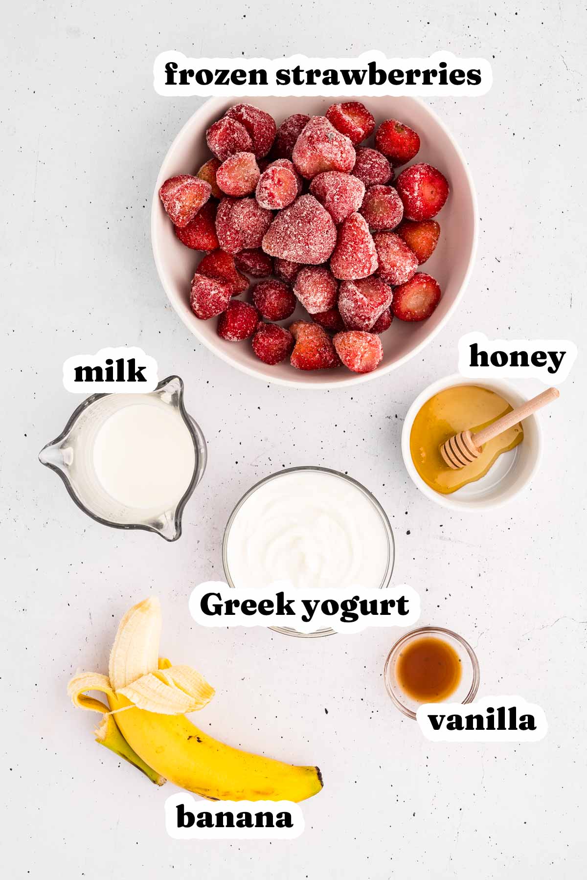 overhead view of ingredients to make strawberry banana smoothie with text labels