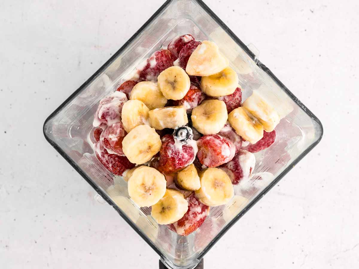 overhead view of strawberries and banana in blender