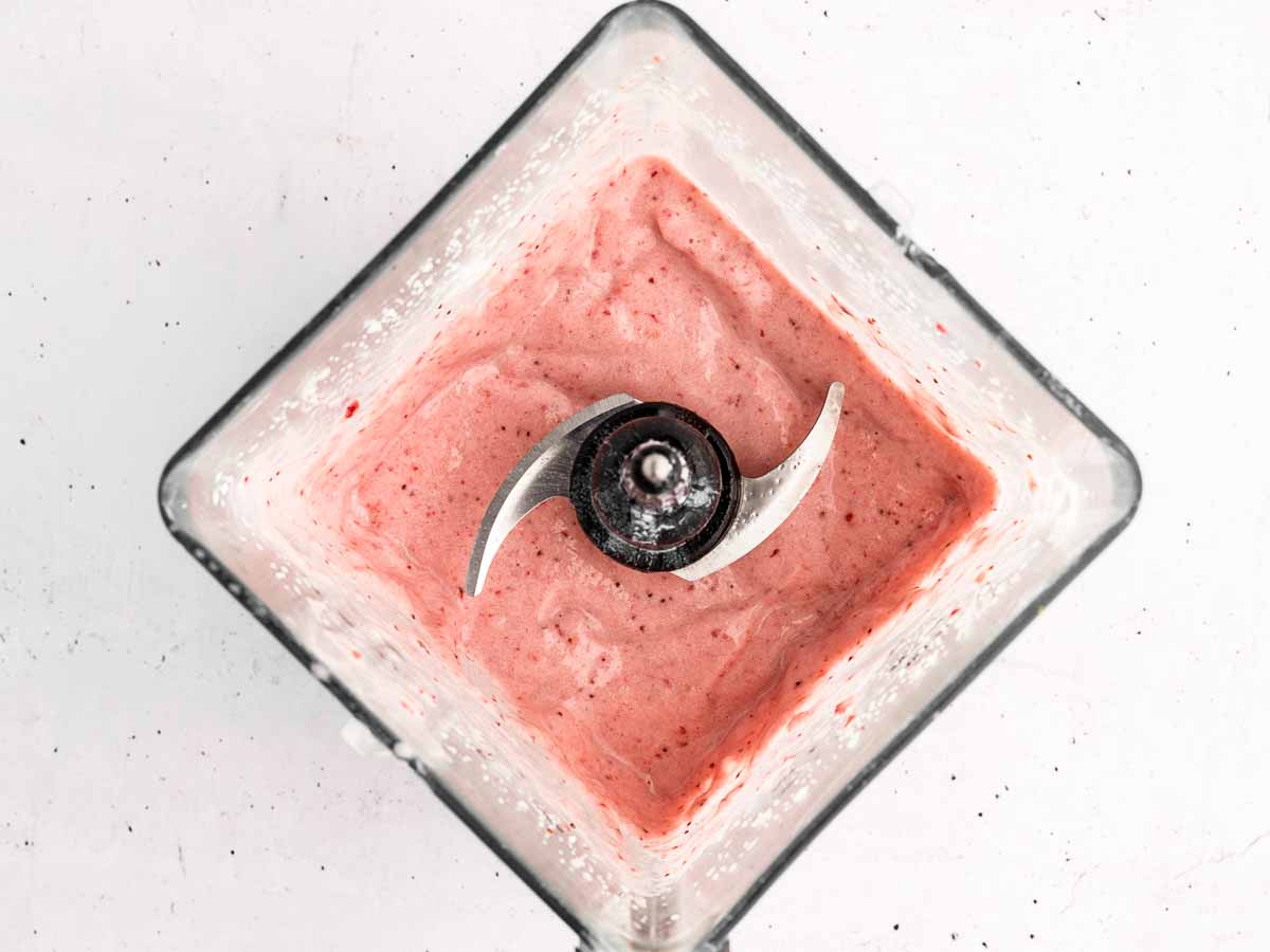 overhead view of strawberry banana smoothie in blender