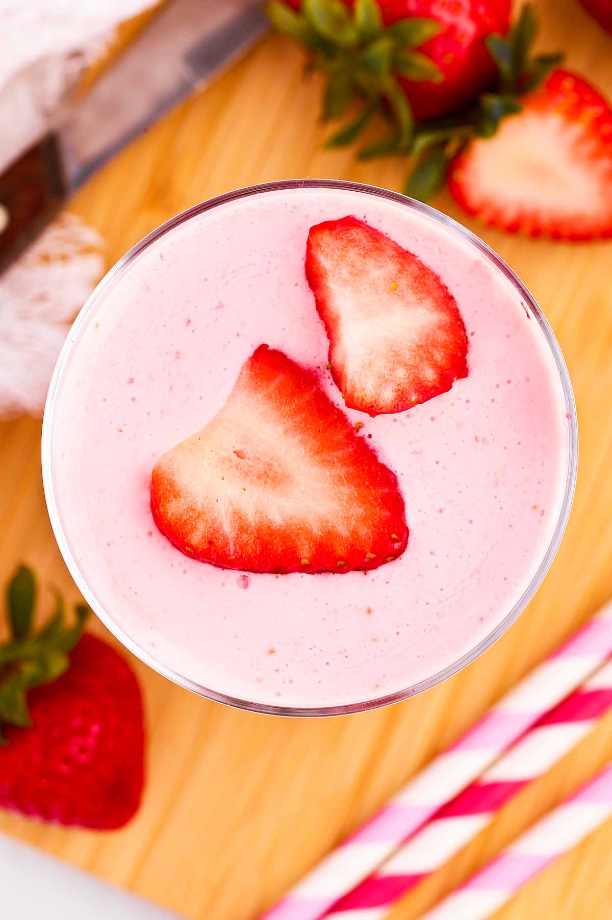 overhead view of strawberry yogurt smoothie topped with fresh strawberry slices