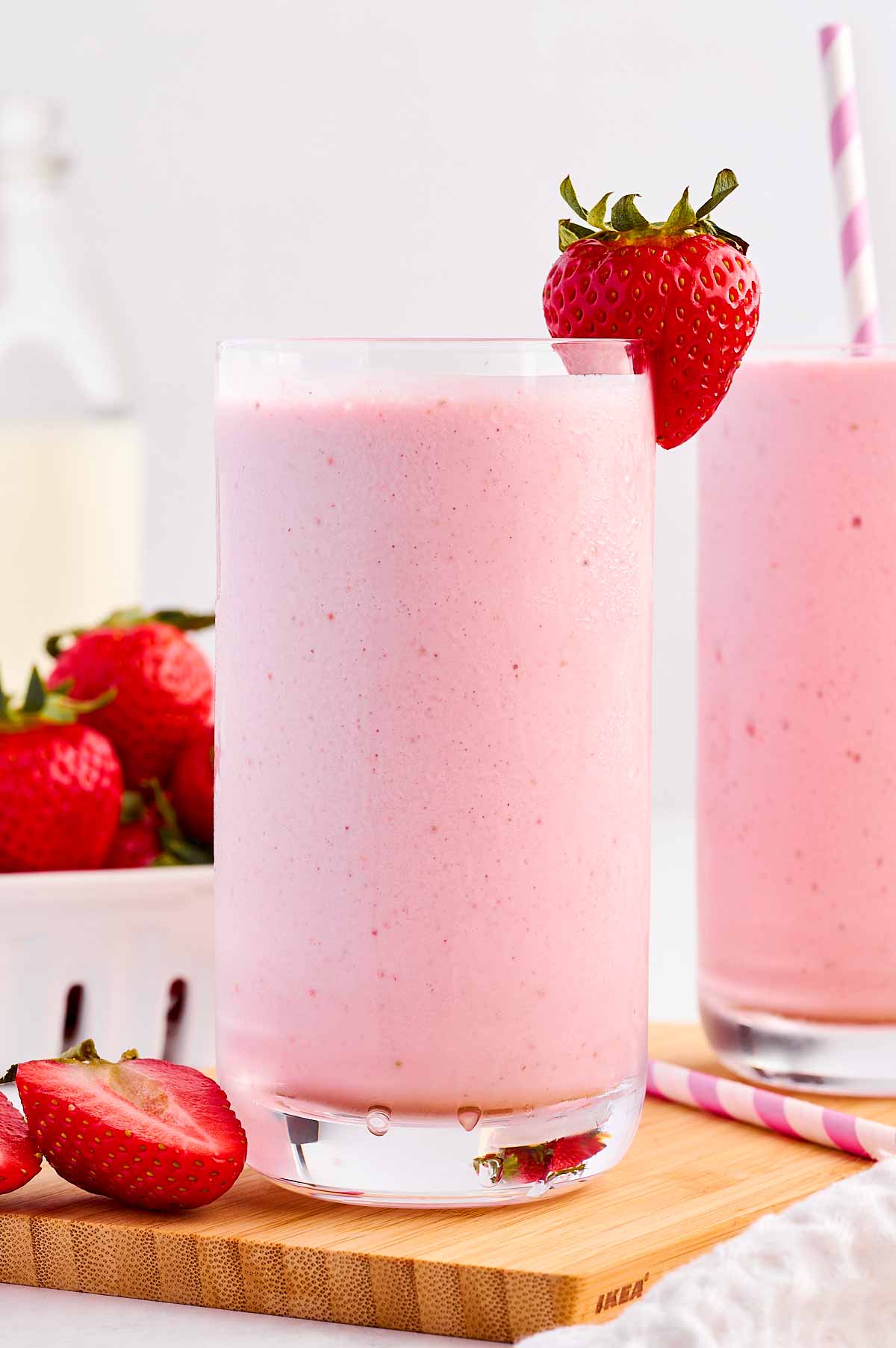 frontal view of strawberry smoothie in glass decorated with fresh strawberries