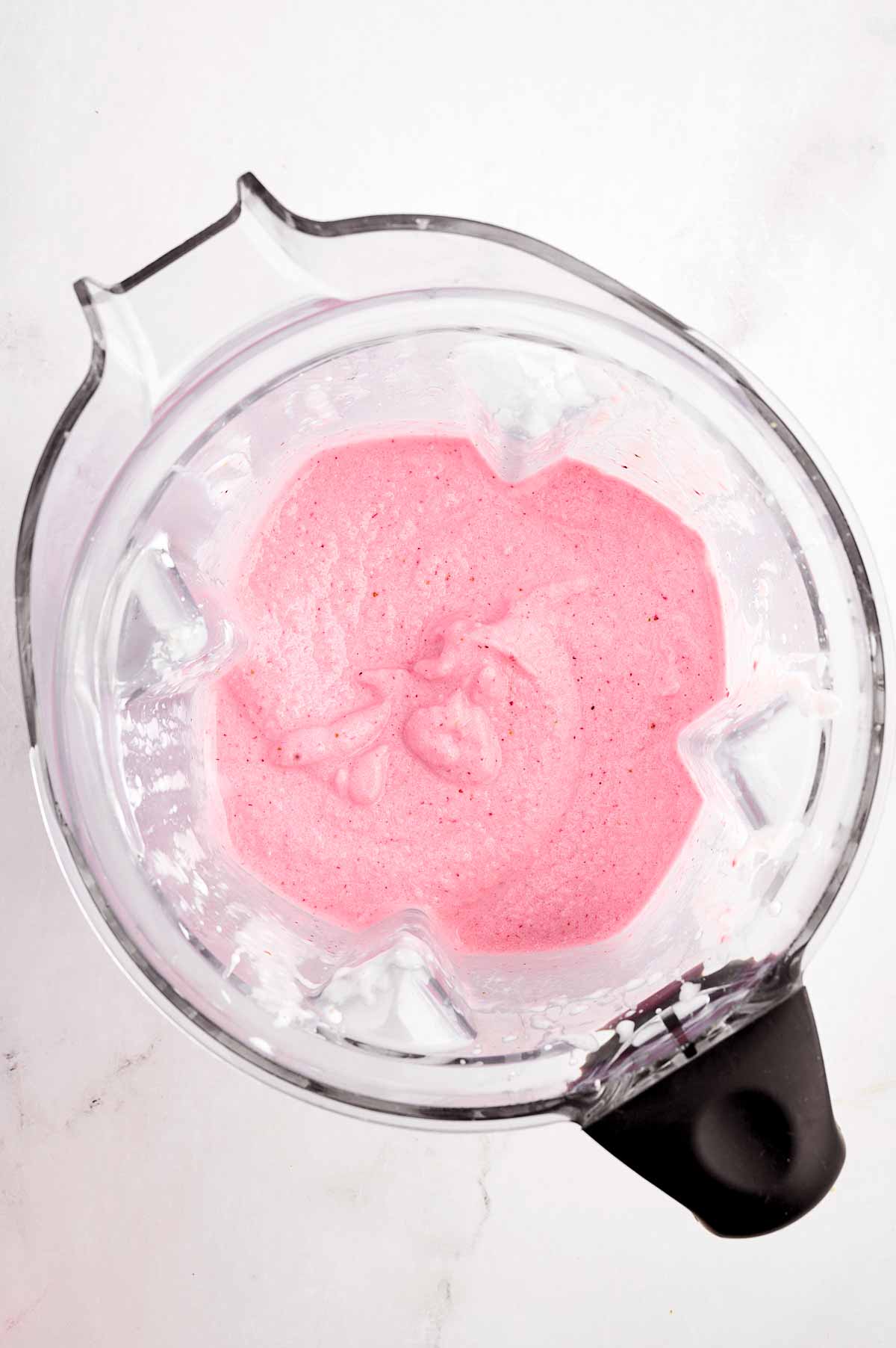 overhead view of strawberry yogurt smoothie in blender cup