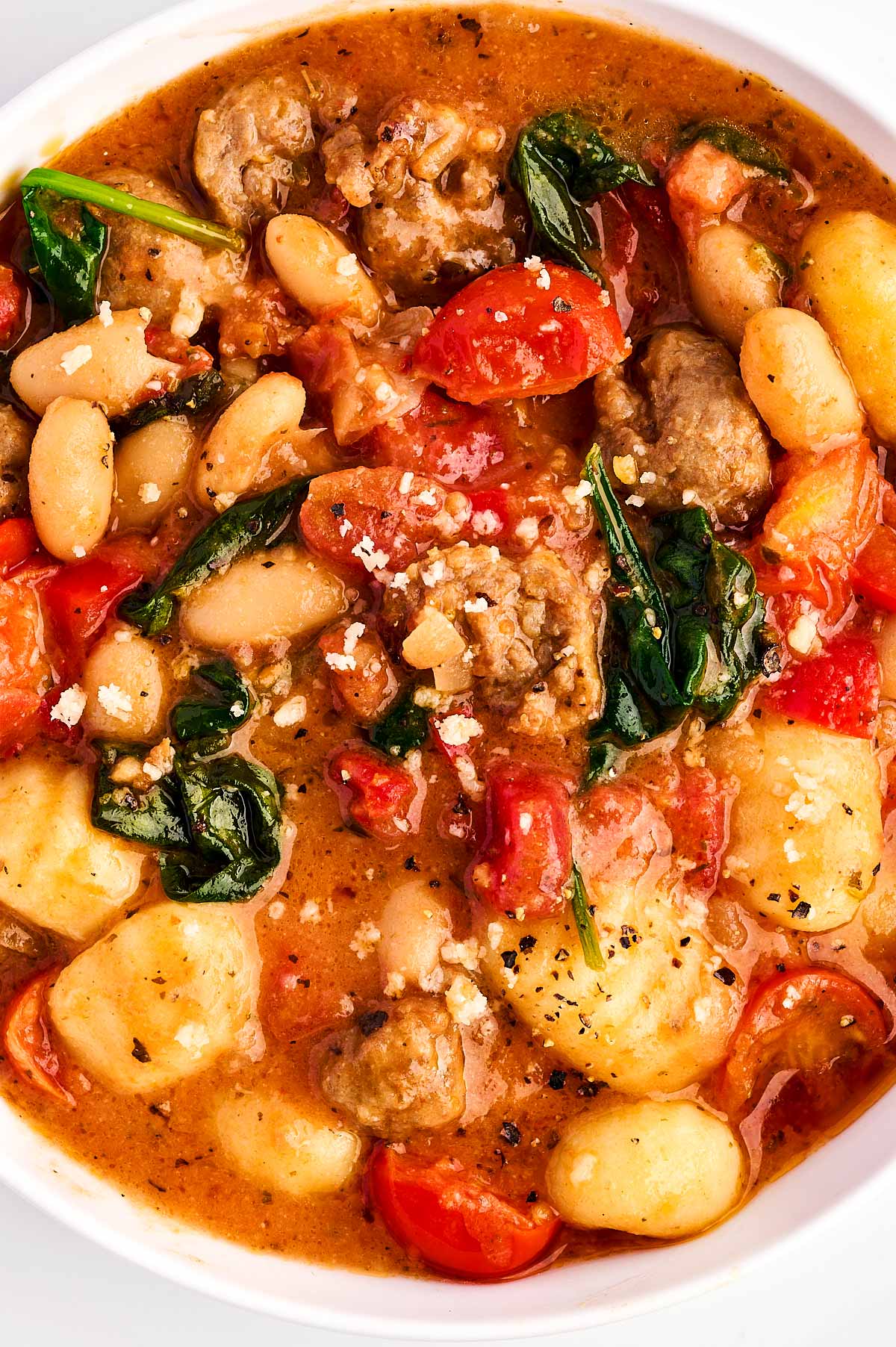 overhead view of tuscan sausage gnocchi in white bowl