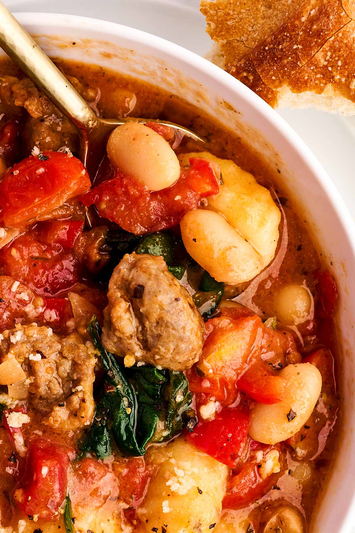 overhead close up view of tuscan sausage gnocchi in white bowl