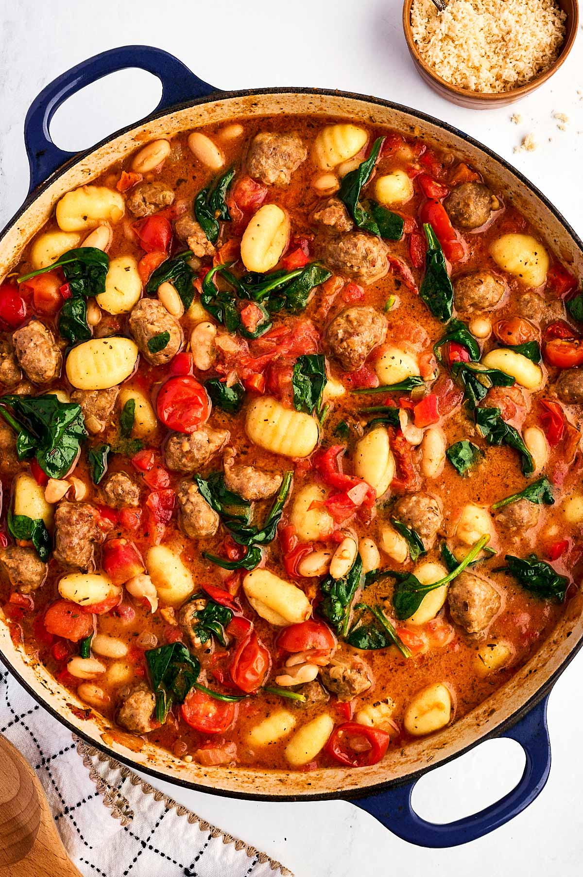 overhead view of tuscan white bean sausage gnocchi in dutch oven