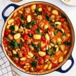 overhead view of tuscan white bean sausage gnocchi in dutch oven